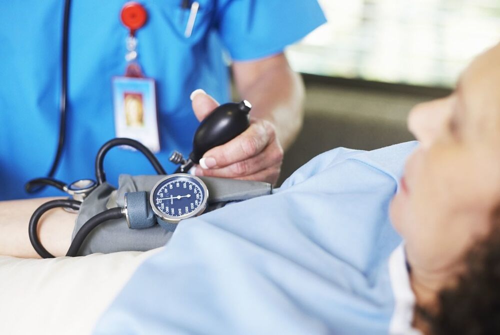 Medicul măsoară presiunea pacientului cu hipertensiune arterială